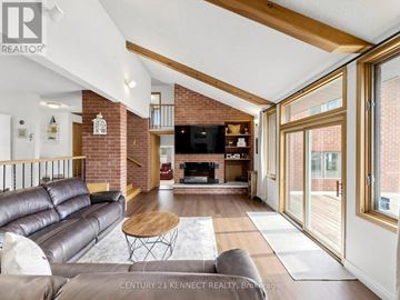 Kawartha Lakes (Eldon) apartment for rent - A living room with a leather couch and a fireplace.