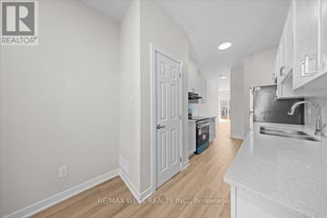 Ottawa townhouse for rent - A white kitchen with a sink and a refrigerator.
