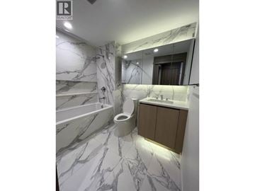 Burnaby apartment for rent - A bathroom with marble tiles and a wooden cabinet.