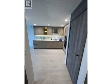 Burnaby apartment for rent - A modern kitchen with a marble countertop and wooden flooring.