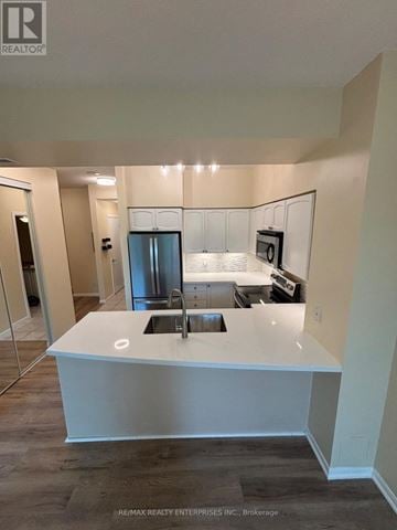 Toronto (Niagara) condo for rent - A modern kitchen with a white island and stainless steel appliances.