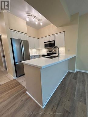 Toronto (Niagara) condo for rent - A kitchen with a white island and wooden floors.