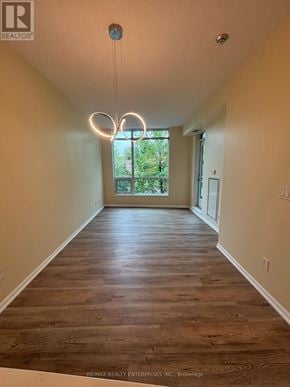 Toronto (Niagara) condo for rent - A long hallway with wood floors and a light fixture hanging from the ceiling.