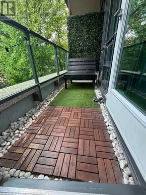 Toronto (Niagara) condo for rent - A wooden deck with a bench and a glass door.