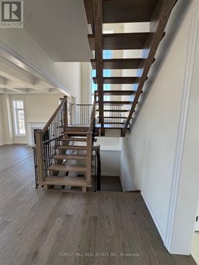 Oro-Medonte (Horseshoe Valley) apartment for rent - A wooden staircase with a metal railing in a white room.