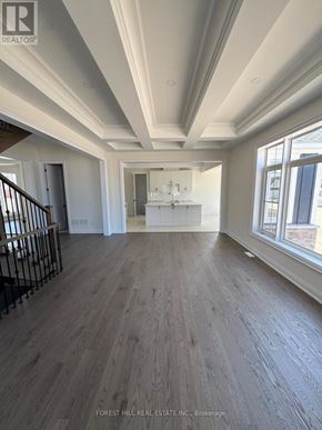 Oro-Medonte (Horseshoe Valley) apartment for rent - A spacious room with wood flooring and a staircase with metal railings.