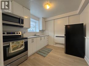 Kitchener apartment for rent - A kitchen with a black fridge and a black oven.