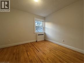 Kitchener apartment for rent - A room with wooden floors and a window with a white frame.