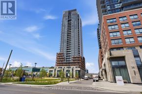 Toronto (Thorncliffe Park) condo for rent - A tall building with a glass facade stands next to a shorter building with a brick facade.