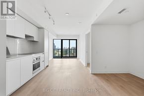 Toronto (Thorncliffe Park) condo for rent - A spacious, empty room with a view of the city through a large window.