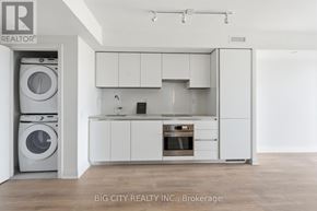 Toronto (Thorncliffe Park) condo for rent - A white kitchen with a washer and dryer in the corner.