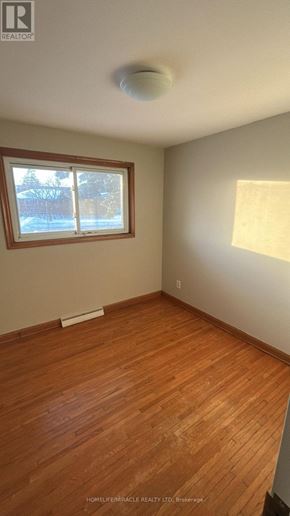 St. Catharines (Oakdale) apartment for rent - A room with a window and wooden flooring.
