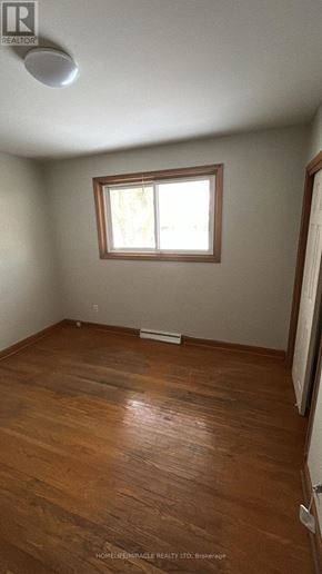St. Catharines (Oakdale) apartment for rent - A room with wooden floors and a window.