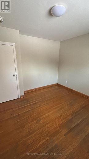 St. Catharines (Oakdale) apartment for rent - A room with wooden floors and a white ceiling light.