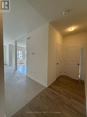 Loyalist (Bath) apartment for rent - A hallway with a door on the right and a window in the distance.