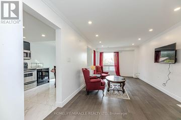 Oshawa (Pinecrest) apartment for rent - A spacious living room with a red chair and a coffee table.