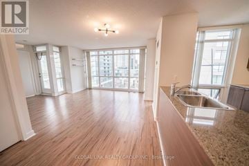 Toronto (Waterfront Communities) condo for rent - A spacious kitchen with wooden floors and a large window overlooking the city.