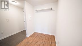Toronto (Waterfront Communities) condo for rent - A white room with a wooden floor and a white wall.
