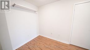 Toronto (Waterfront Communities) condo for rent - A white room with a wooden floor and a white door.