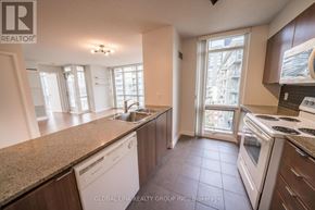 Toronto (Waterfront Communities) condo for rent - A kitchen with white appliances and brown cabinets.