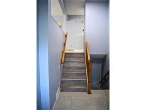Surrey apartment for rent - A staircase with a wooden handrail and tiled steps.