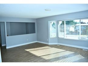 Surrey apartment for rent - A room with a large window and a wooden floor.