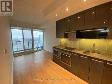 Toronto (Bayview Village) condo for rent - A kitchen with dark brown cabinets and a stainless steel sink.