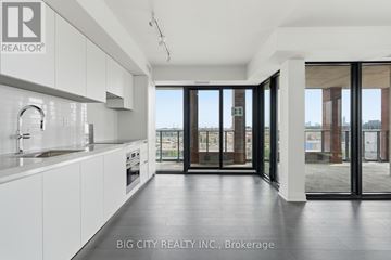 Toronto (Leaside) condo for rent - A modern kitchen with white cabinets and a large window.