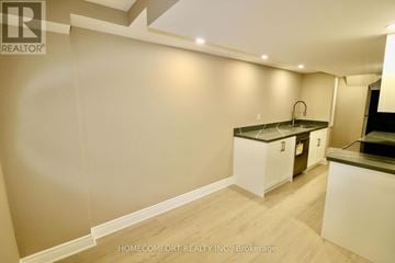 Richmond Hill (Westbrook) apartment for rent - A kitchen with white cabinets and a black countertop.