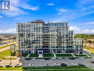 Hamilton (Stoney Creek) condo for rent - A large, modern building with a glass facade is the main focus of the image.