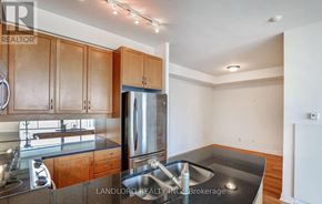Toronto (Annex) condo for rent - A kitchen with wooden cabinets and a stainless steel refrigerator.