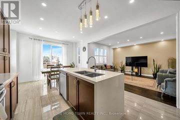 Centre Wellington (Fergus) apartment for rent - A modern kitchen with a large island and a living area with a couch and a TV.