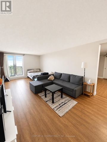 Ottawa condo for rent - A living room with a grey couch and a wooden floor.