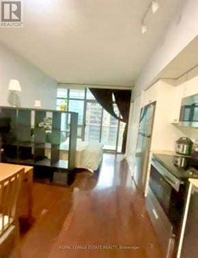 Toronto (Church-Yonge Corridor) condo for rent - A kitchen with a stove top oven and a dining table.