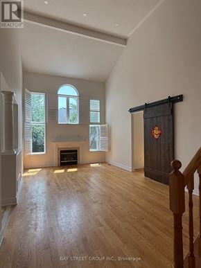 Markham (Berczy) apartment for rent - A spacious room with a fireplace and wooden flooring.