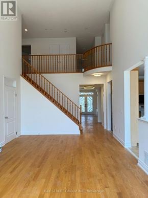 Markham (Berczy) apartment for rent - A spacious hallway with a wooden staircase and white walls.