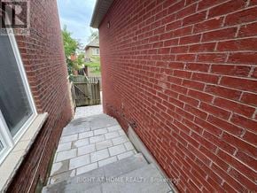 Vaughan (Patterson) apartment for rent - A red brick wall with a window on the left and a wooden fence in the background.