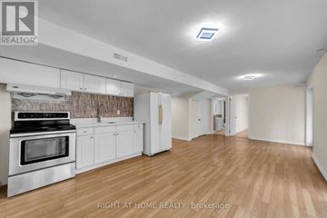 Vaughan (Patterson) apartment for rent - A kitchen with white cabinets and a stove top oven.