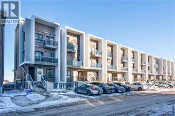 Kitchener condo for rent - A row of modern apartment buildings with cars parked in front.