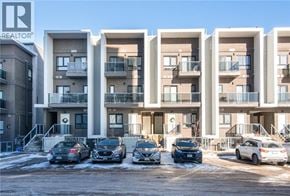 Kitchener condo for rent - A row of modern apartment buildings with cars parked in front.