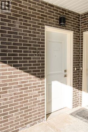 Kitchener condo for rent - A white door is on the left side of a brick wall.