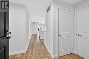 Hamilton (Ancaster) condo for rent - A hallway with white doors and a black door on the left.