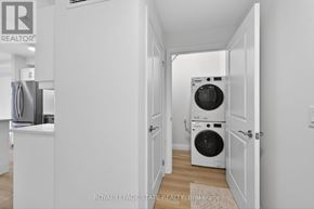 Hamilton (Ancaster) condo for rent - A white laundry room with a washer and dryer.