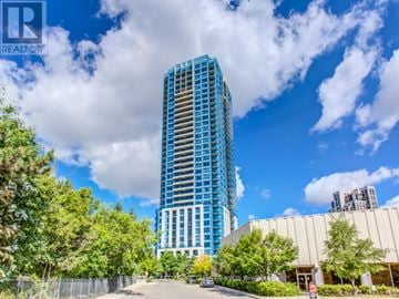 Toronto (Banbury-Don Mills) condo for rent - A tall blue building stands in front of a cloudy sky.