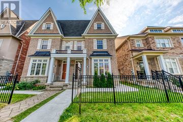 Mississauga (Churchill Meadows) apartment for rent - A large, well-maintained house with a brick facade and a black metal fence in front.