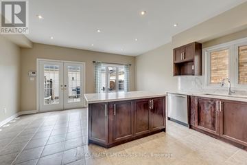 Mississauga (Churchill Meadows) apartment for rent - A kitchen with brown cabinets and a marble countertop.