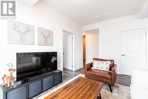 Hamilton (Waterdown) condo for rent - A living room with a brown leather chair and a black entertainment center.