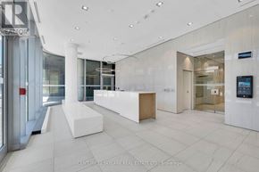 Toronto (Annex) condo for rent - A modern office lobby with a reception desk and a flat screen TV mounted on the wall.