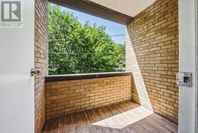 Hamilton (Durand) condo for rent - A balcony with a wooden railing and steps leading to a door.