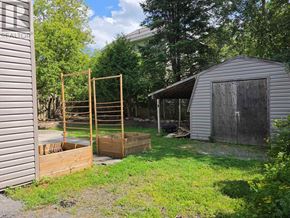 Huntsville apartment for rent - A backyard with a shed and a wooden fence.
